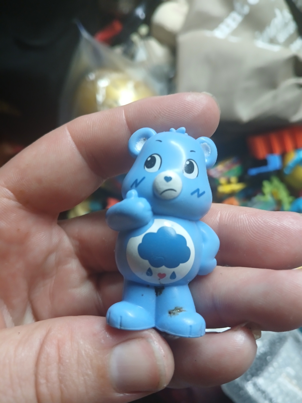 small plastic figurine of Grumpy Bear from the Care Bears franchise
